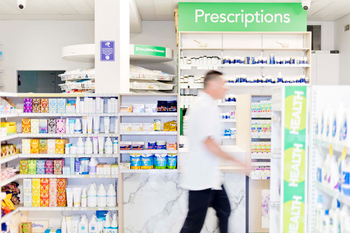 Pharmacist beside a cabinet of medicines